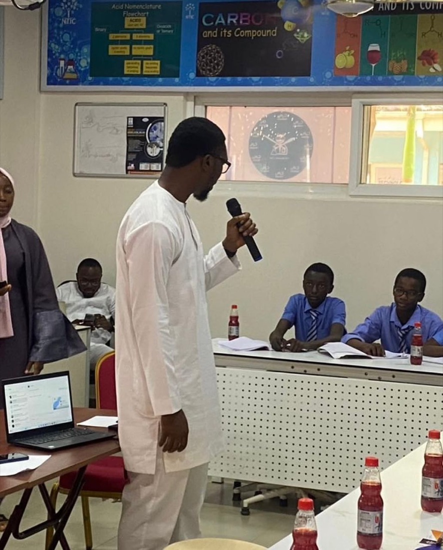 A Teqia volunteer speaking to secondary school students during a sensitization session