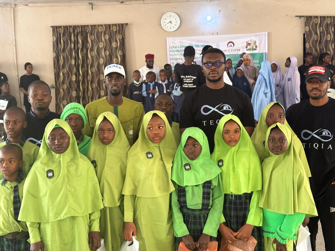 Teqia team members standing with students in school uniforms at a community outreach event